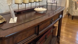 Un tavolo consolle in legno con candele, un quadro incorniciato e una rivista.