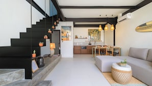 Un interior moderno con una escalera, un comedor y una sala de estar.