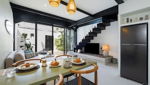 Una cocina moderna con zona de comedor, una escalera y un televisor.