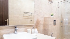 Un baño moderno con un lavamanos grande, espejo y ducha.