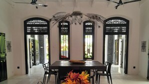 Un comedor amplio con una mesa larga, sillas negras y jarrones decorativos.