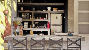 A kitchen with a central island, built-in shelves, and a refrigerator.