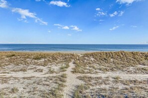 A beach with sand dunes and a clear view of the ocean.