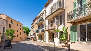Una calle adoquinada con edificios que tienen balcones y contraventanas.