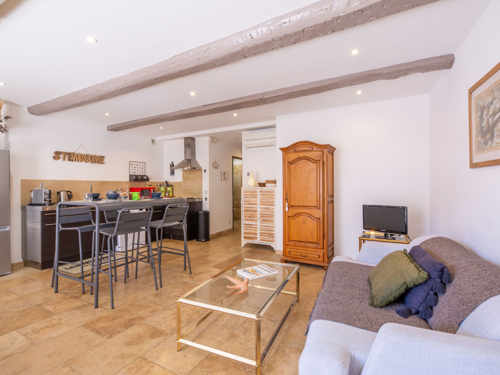 Une cuisine moderne avec un coin bar, une armoire en bois et un salon confortable avec un canapé et une table basse.