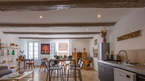 Una cocina amplia con comedor, vigas de madera en el techo y vista al salón.