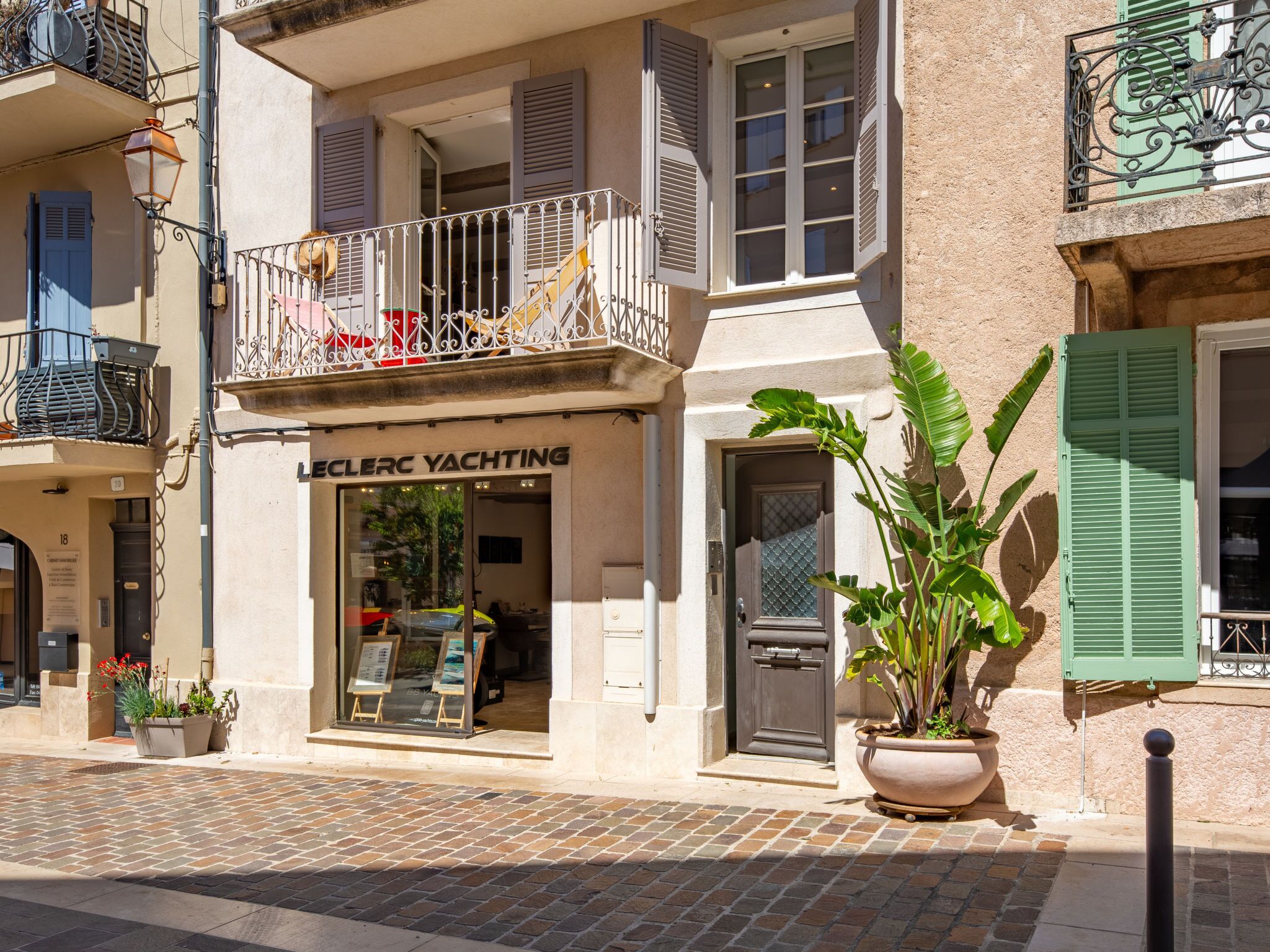 A building with a storefront labeled "LECLERC YACHTING" and a balcony with a railing.