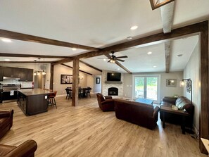 A spacious living area with a fireplace, a dining area, and a kitchen with modern appliances.