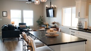 A modern kitchen with a central island, dining area, and seating. - The Little Boise Bungalow (Boise)