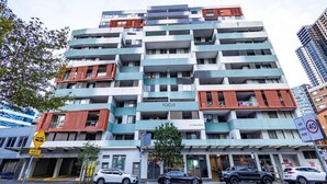 Un edificio de varios pisos con balcones, un letrero que dice "FOCUS" y una señal de velocidad que indica 40.