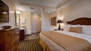 Ein Hotelzimmer mit einem großen Bett, einer Holzkommode und einem Spiegel.
