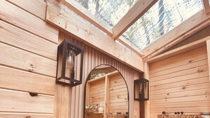 A wooden cabin bathroom with a skylight, a round sink, a mirror, and wooden shelves. - • TRANQUILITY DOME• OFFGRID GLAMPING RETREAT IN PRIVATE FOREST! (Killaloe)