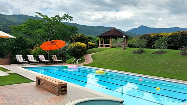 A swimming pool with lounge chairs, a gazebo, and a view of mountains. - Casa rodeada de naturaleza en Villeta (Villeta)