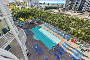 A rooftop pool area with multiple lounge chairs and a swimming pool.