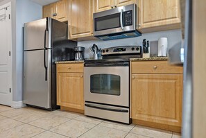 Una cocina con electrodomésticos de acero inoxidable, gabinetes de madera y encimera de granito.