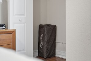 Una habitación con un aparador de madera, una puerta blanca y una bolsa negra grande con la palabra 'GRACO'.