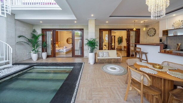 A spacious living area with a pool, a dining area, and a bedroom with a sliding glass door.