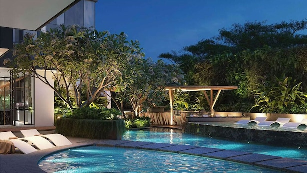 Ein moderner Poolbereich im Freien mit Liegestühlen, einer Pergola und üppiger Bepflanzung.