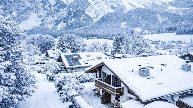 A snow-covered mountain landscape with a lodge featuring a wooden exterior and solar panels on the roof. - Landhaus Kunze by Interhome (Gröbming)