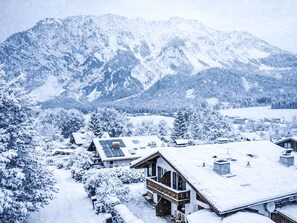 A snow-covered mountain landscape with a lodge featuring a wooden exterior and solar panels on the roof. - Landhaus Kunze by Interhome (Gröbming)