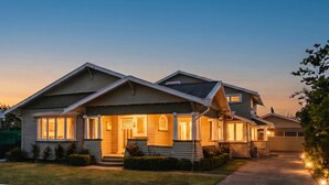 A two-story house with a front porch, a driveway, and a well-maintained lawn.