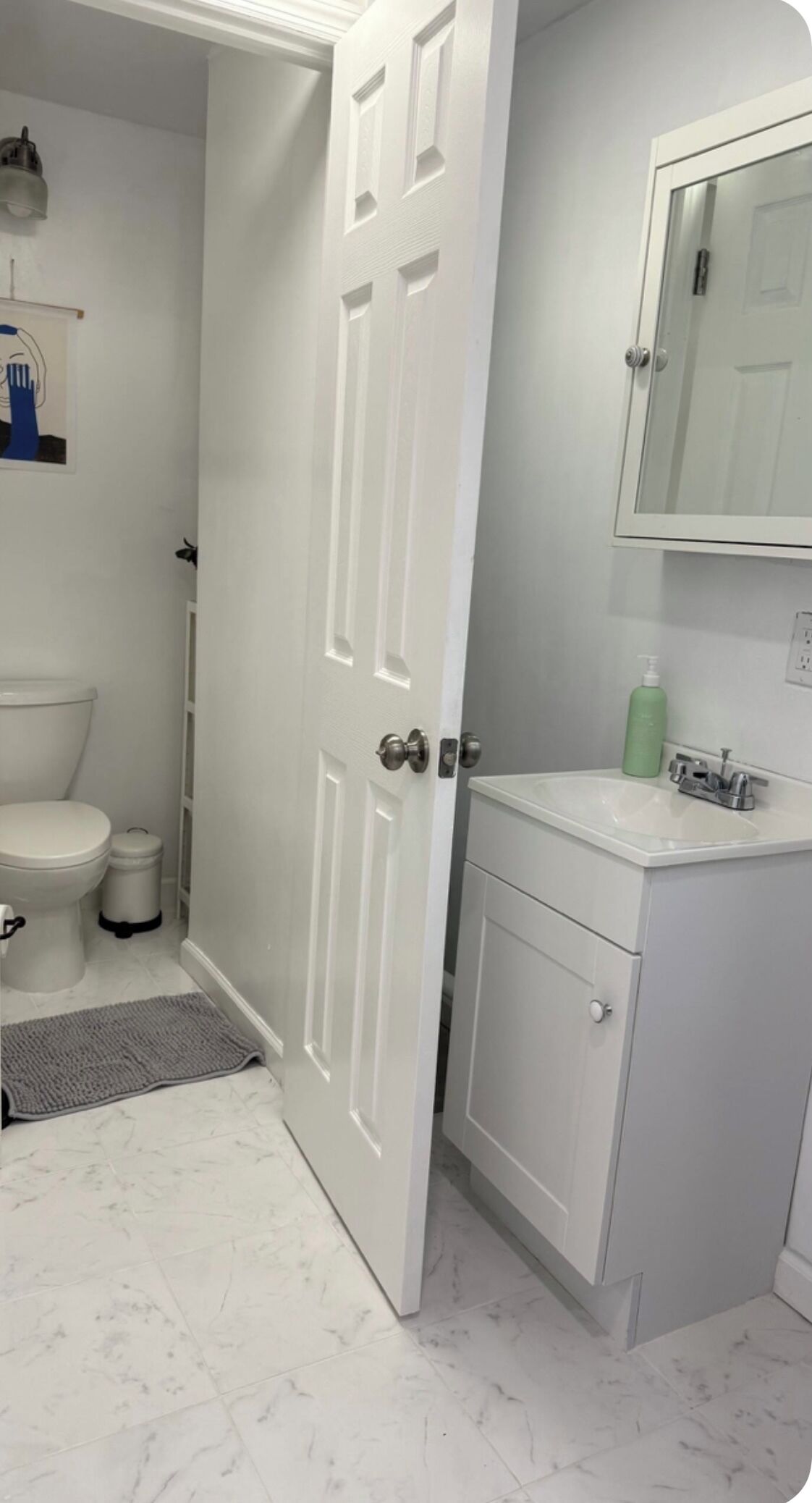 Un baño con inodoro, lavamanos y espejo.