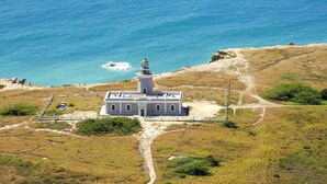 A coastal building with a lighthouse, surrounded by a natural landscape and a clear view of the sea. - Peaceful Hideaway in Cabo Rojo (Boquerón)