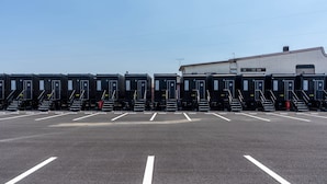 A parking lot with rows of shipping containers, each marked with a number.