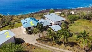 A coastal property with numbered buildings, likely part of a resort or vacation rental, featuring a view of the ocean and surrounding landscape. - Kona Coast, BEST Oceanview Pool, Yoga Meditation Space, Pickle Ball Basket Ball (Captain Cook)