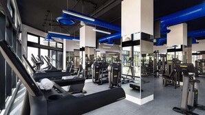 Una sala de gimnàstica moderna amb cintes de córrer, màquines de peses i equip d'exercici.