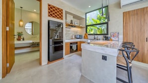 A modern kitchen with a central island, built-in appliances, and a large window providing natural light.
