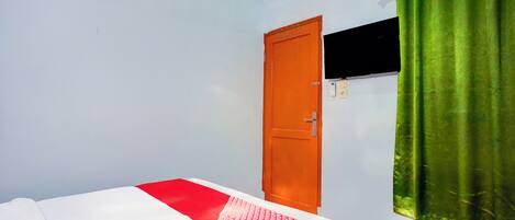 Una habitación con cama, puerta, ventana y cortina.