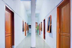 A corridor with doors on both sides, leading to rooms. - Hotel O Clove Nari Homestay (Medan)