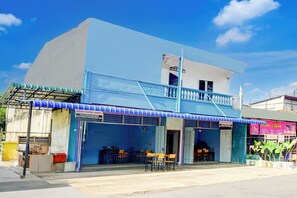 A two-story building with a blue and white facade, a balcony, and outdoor seating area. - Hotel O Clove Nari Homestay (Medan)