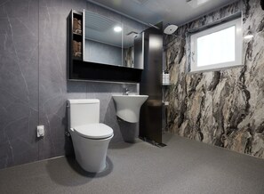 A modern bathroom with a toilet, bidet, and a large mirror. - Namhae German Village Hercules  (Namhae)