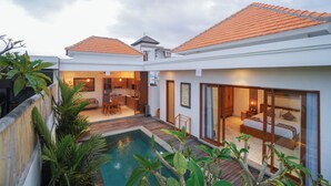 A modern villa with a swimming pool, a dining area, and a bedroom with a large window.