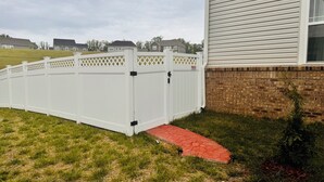 A white wooden fence with a lattice top, a brick wall, and a red pathway leading to a house. - Charming 2-bedroom Basement Apt with WiFi, AC in delightful Bryans Road Maryland (Bryans Road)
