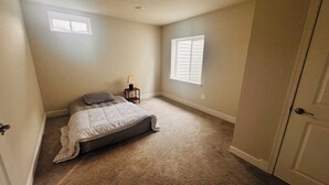 A bedroom with a bed, two windows, a nightstand, and a door. - Charming 2-bedroom Basement Apt with WiFi, AC in delightful Bryans Road Maryland (Bryans Road)