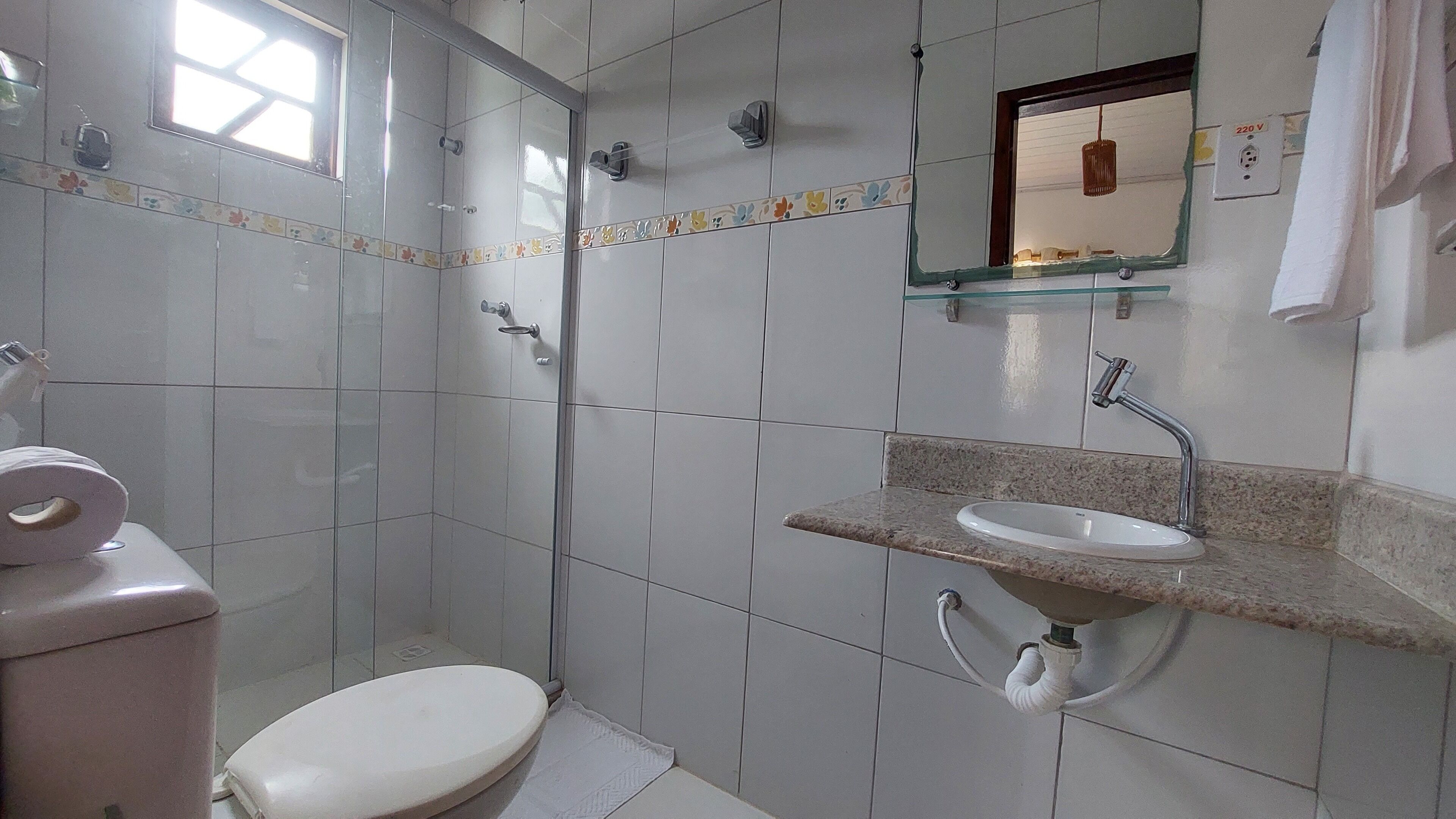 A bathroom with a toilet, a sink, and a shower.