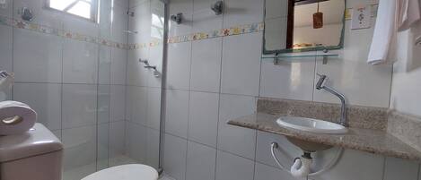 A bathroom with a toilet, a sink, and a shower.