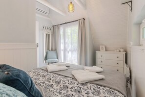 Makuuhuoneessa on sänky, lipasto, tuoli ja riippuvalaisin.