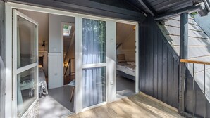 A bedroom with a bed, a window with curtains, and a wooden floor. - Balchill House With Sauna And Jacuzzi (Balatonszepezd)