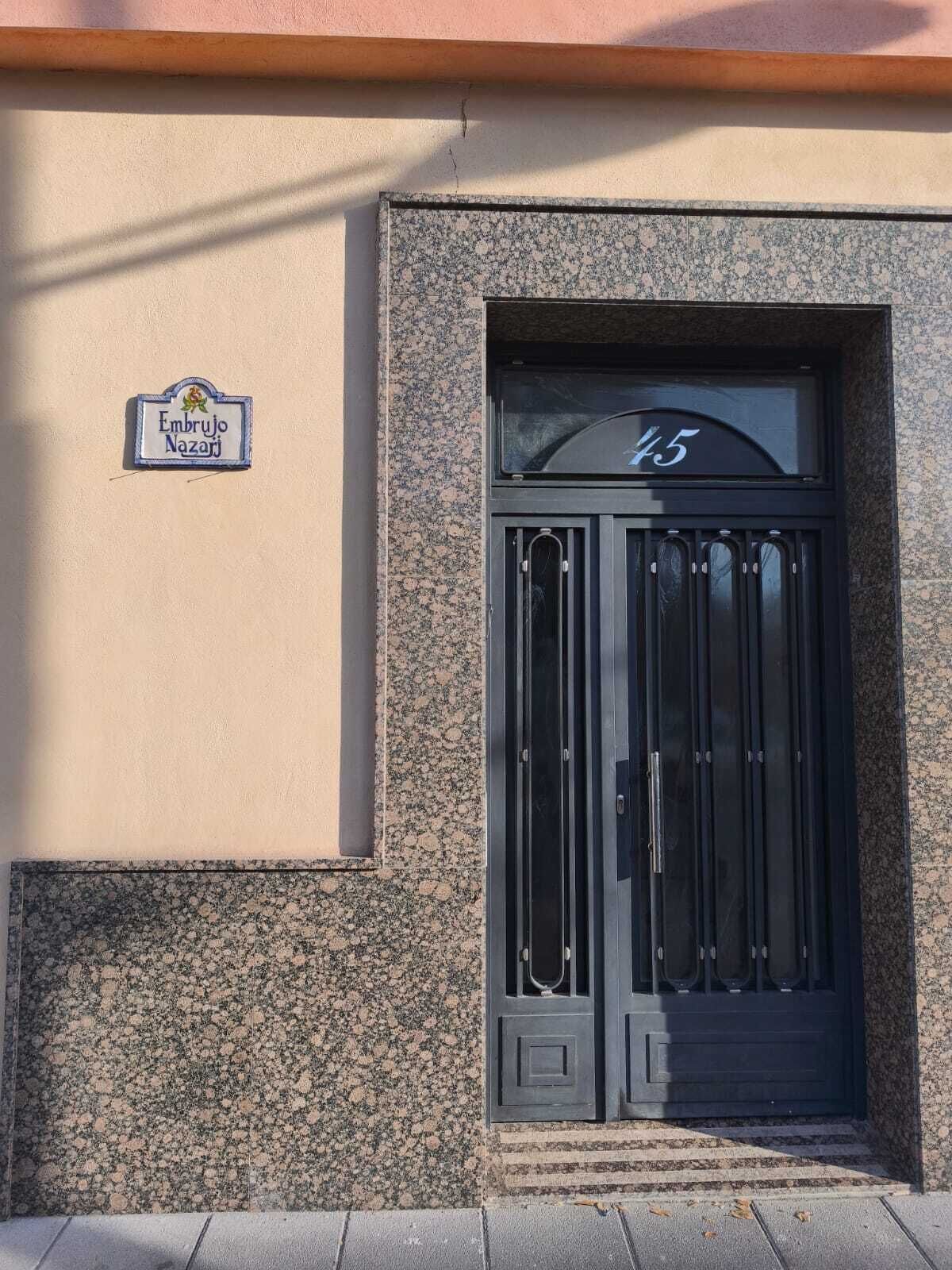 Ein Gebäudeeingang mit einem Schild, auf dem "Embrujo Nazari" steht, und der Hausnummer "45".