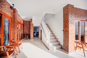 Een modern interieur met een trap, bakstenen muren en houten meubels.