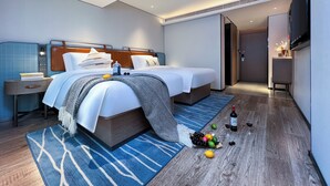 Een moderne hotelkamer met een groot bed, nachtkastje en een flatscreen televisie.
