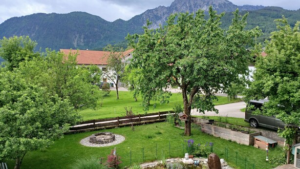 A garden with a pond, a wooden fence, and a mountain backdrop. - Apartment 55 sqm for 2 persons with balcony and mountain view (Anger)