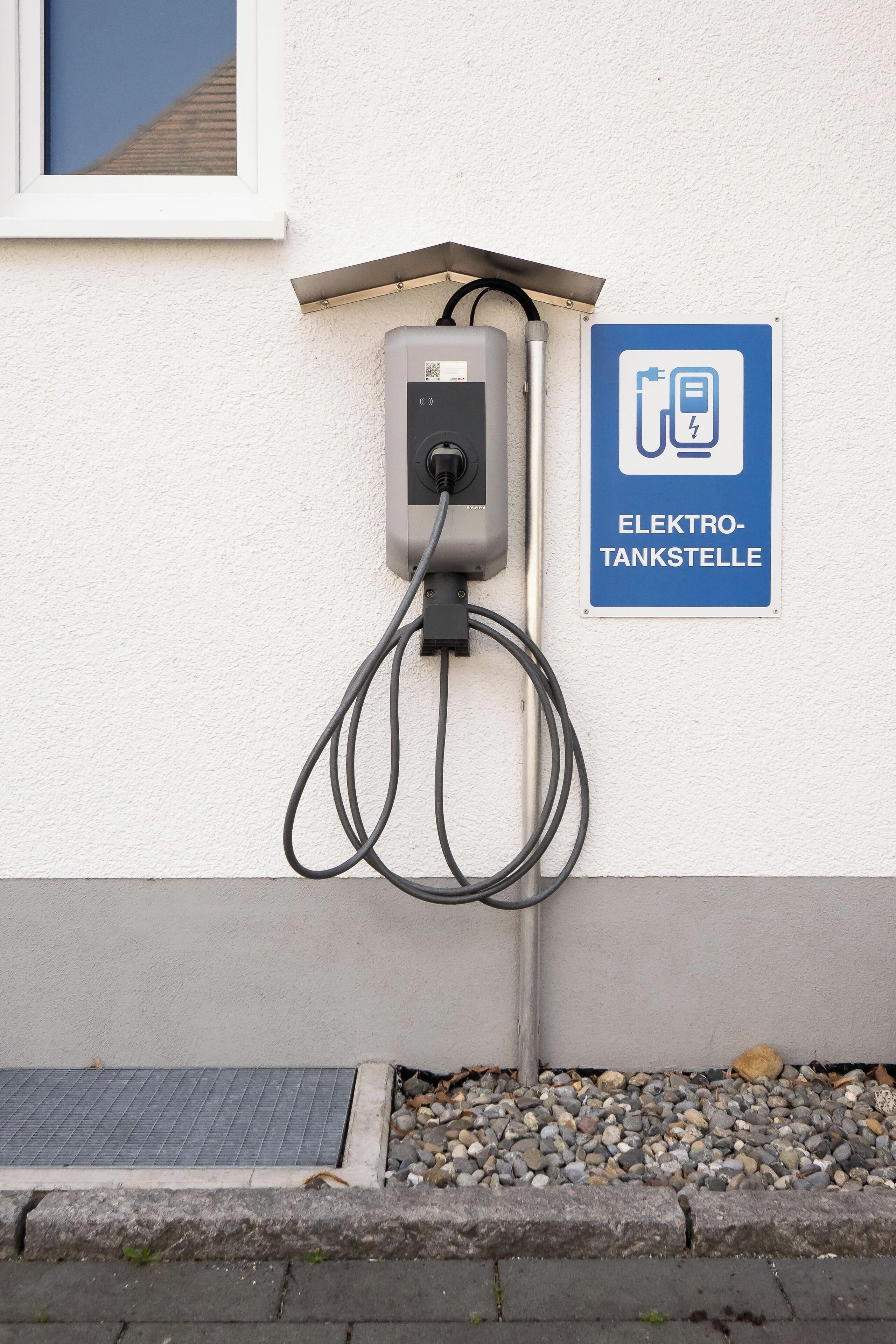An electric vehicle charging station with a sign indicating its purpose.