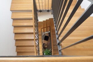 Una escalera moderna con escalones de madera y barandillas de metal.