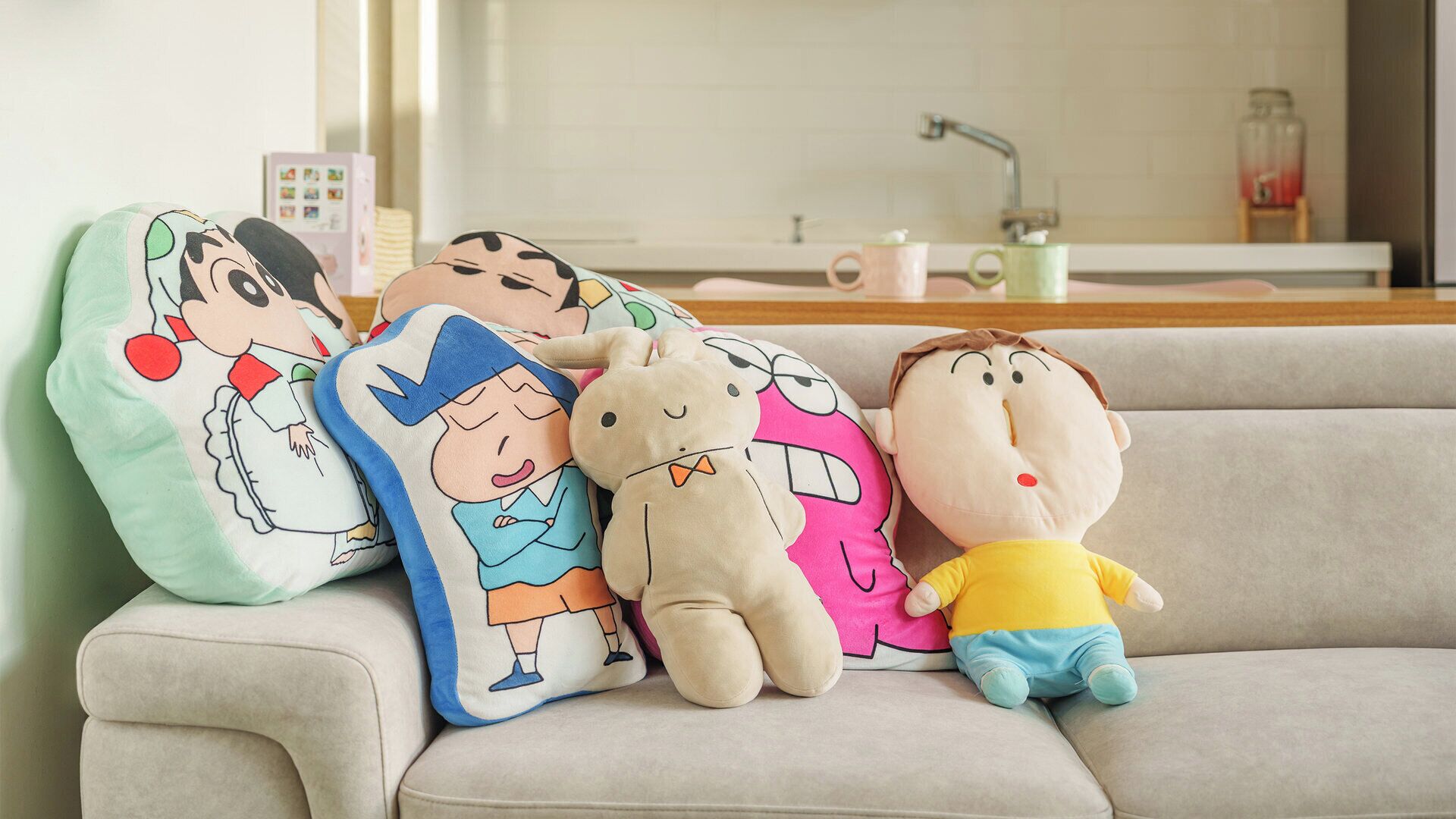 A sofa with plush toys and pillows.