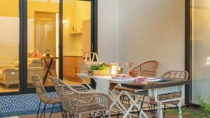 A dining area with wicker chairs, a table with a white tablecloth, and a view of a pool through large glass doors. - Gyeongju Rose Breeze Pool Villa Pension (Gyeongju)